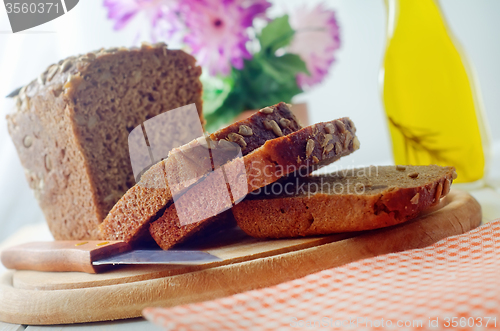 Image of Fresh bread and knife on the wooden board