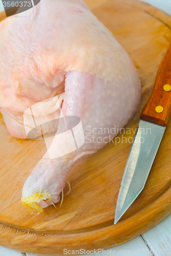 Image of Raw chicken and knife on the wooden board