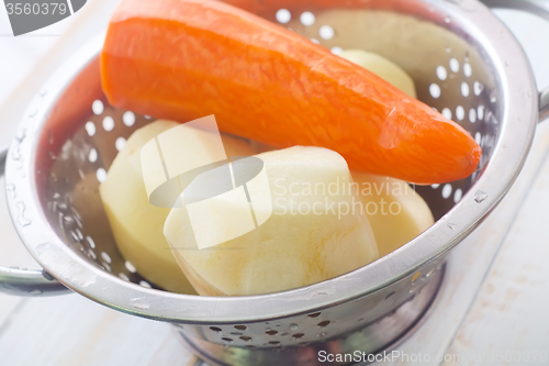 Image of Raw potato and carrot in the metal bowl