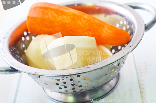 Image of Raw potato and carrot in the metal bowl
