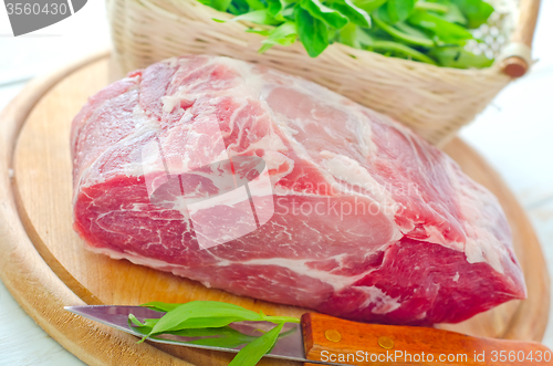 Image of raw meat and knife on the wooden board