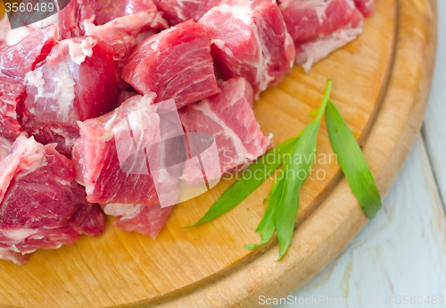 Image of raw meat and knife on the wooden board