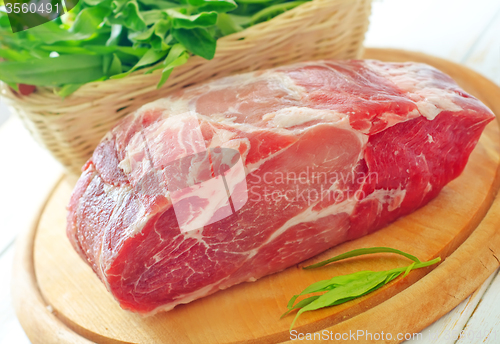 Image of raw meat and knife on the wooden board