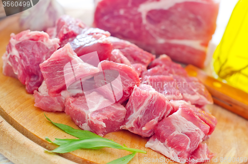 Image of raw meat and knife on the wooden board