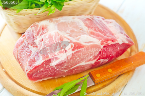 Image of raw meat and knife on the wooden board