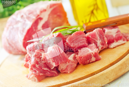 Image of raw meat and knife on the wooden board