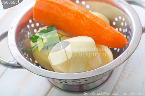 Image of Raw potato and carrot in the metal bowl