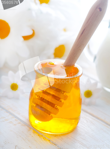 Image of fresh honey in the glass bank and milk in jug