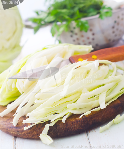 Image of Raw cabbage and knife on the wooden board