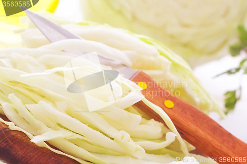 Image of Raw cabbage and knife on the wooden board