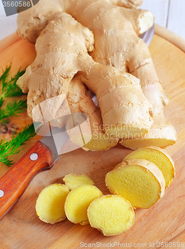 Image of Fresh ginger and knife on the wooden board