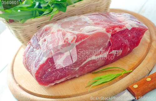 Image of raw meat and knife on the wooden board