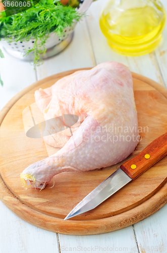 Image of Raw chicken and knife on the wooden board
