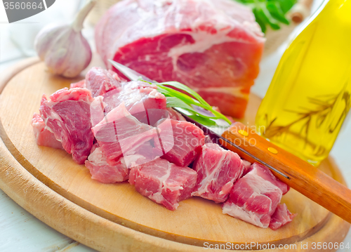 Image of raw meat and knife on the wooden board