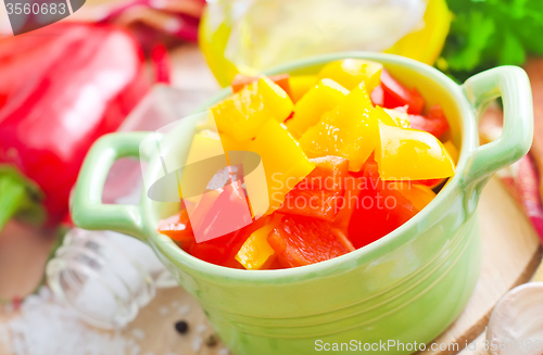 Image of Rd and yellow peppers on wooden background