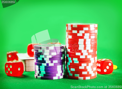 Image of Chips for poker and cubes on the green background