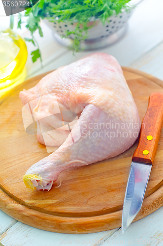 Image of Raw chicken and knife on the wooden board