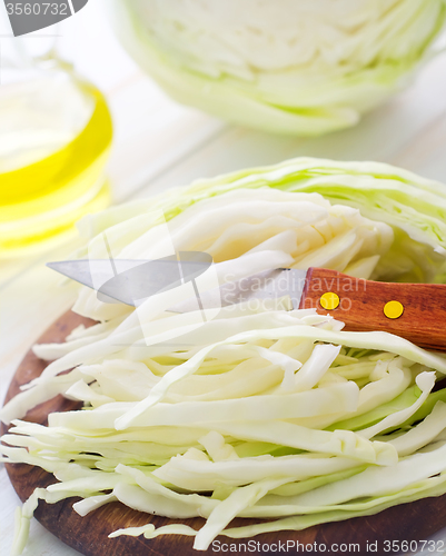 Image of Raw cabbage and knife on the wooden board