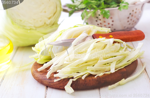 Image of Raw cabbage and knife on the wooden board