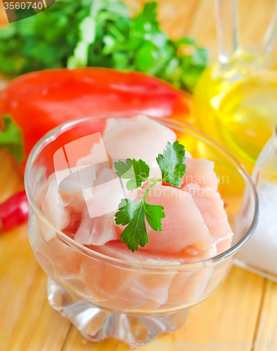 Image of raw chicken and raw vegetables on wooden table