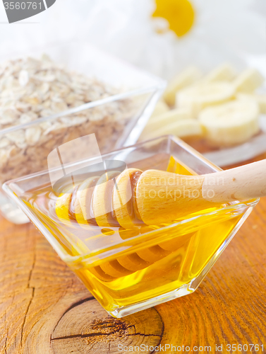 Image of Honey in the glass bowl on the wooden table