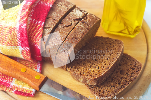 Image of Fresh bread and knife on the wooden board