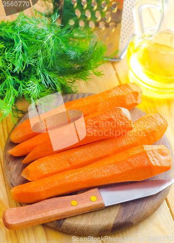 Image of raw carrots and knife on the wooden board