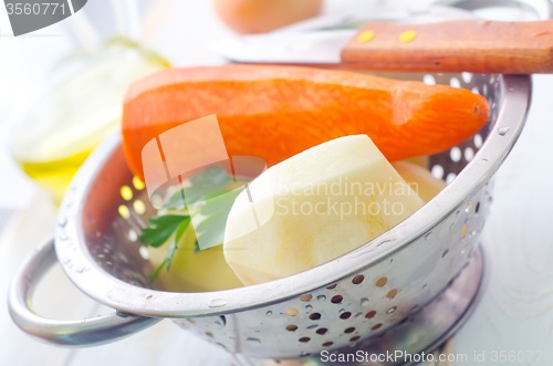 Image of Raw potato and carrot in the metal bowl
