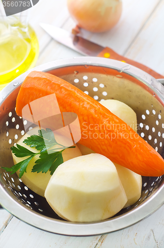Image of Raw potato and carrot in the metal bowl