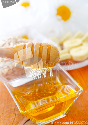 Image of Honey in the glass bowl on the wooden table