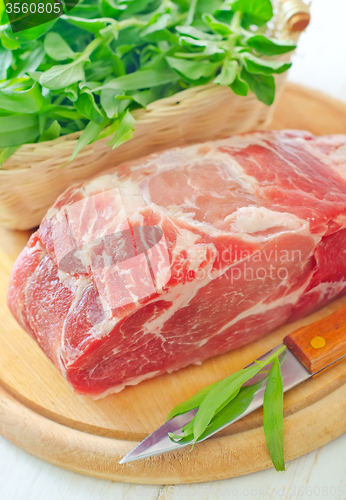 Image of raw meat and knife on the wooden board