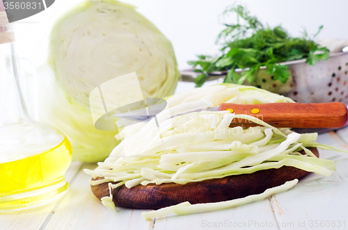 Image of Raw cabbage and knife on the wooden board