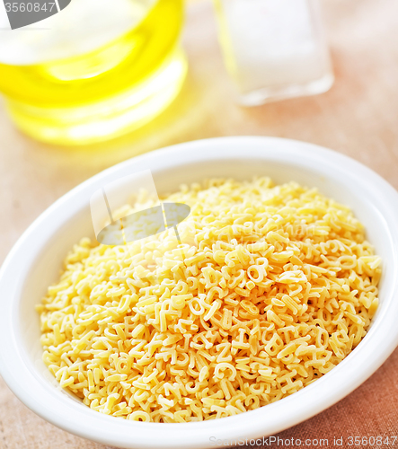 Image of assortment of raw pasta and wheat on wooden background