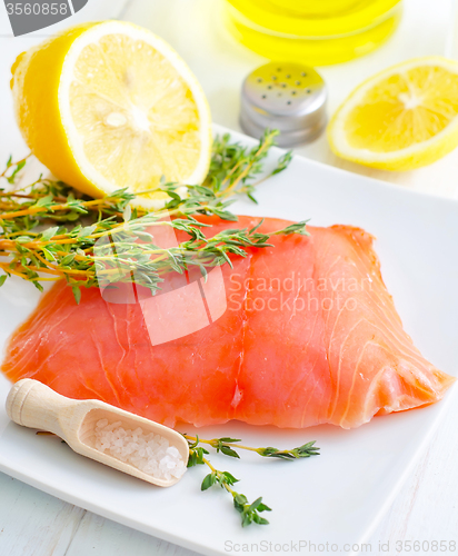 Image of Raw salmon on the white plate with thyme and salt