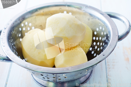 Image of raw potato in the metal bowl