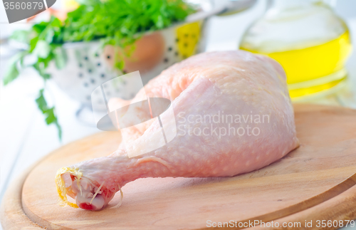 Image of Raw chicken and knife on the wooden board