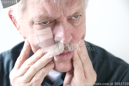 Image of tooth or cheek pain in older man