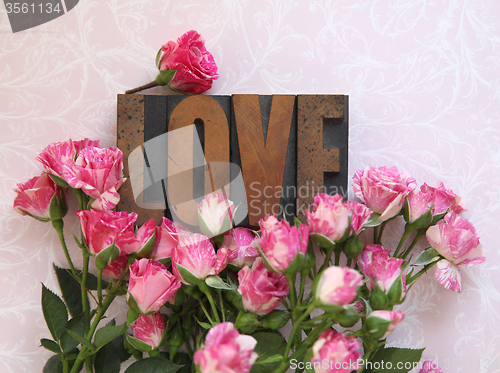 Image of love word in wood type with roses