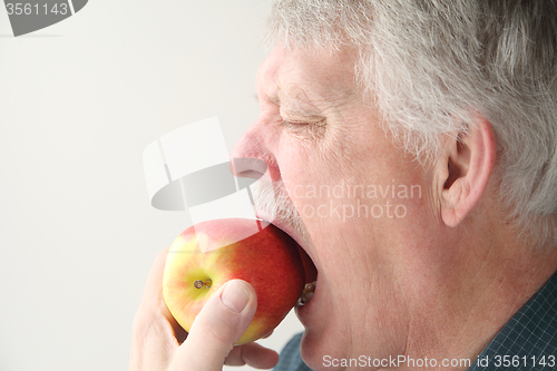 Image of Senior eats apple.	