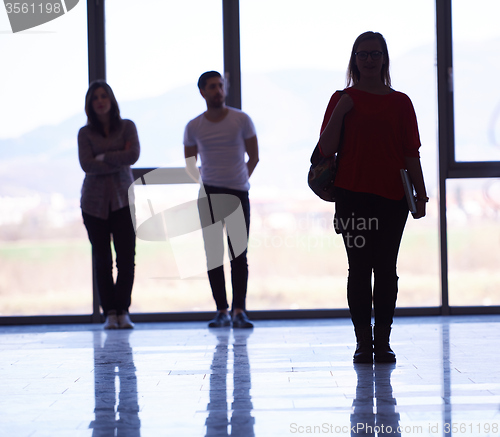 Image of student girl standing with laptop, people group passing by