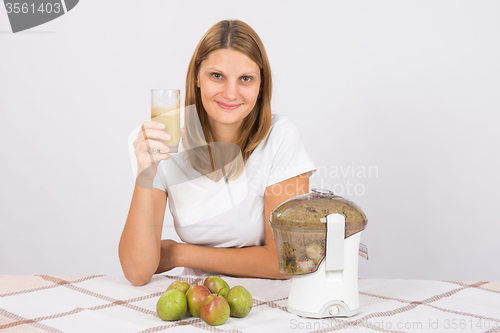 Image of The girl is holding a glass of pear juice