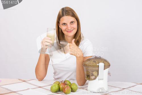 Image of A girl holding a glass of fresh juice and points to it