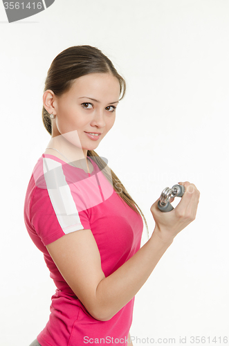 Image of Beautiful athlete with expanders in hand