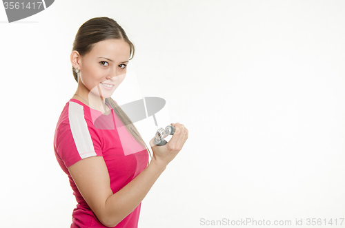 Image of Beautiful female athlete flexing muscles of the hand expanders