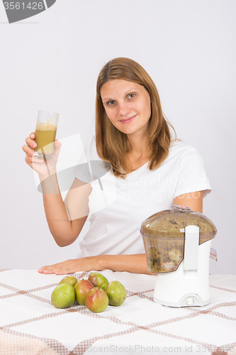 Image of Woman offers freshly squeezed pear juice