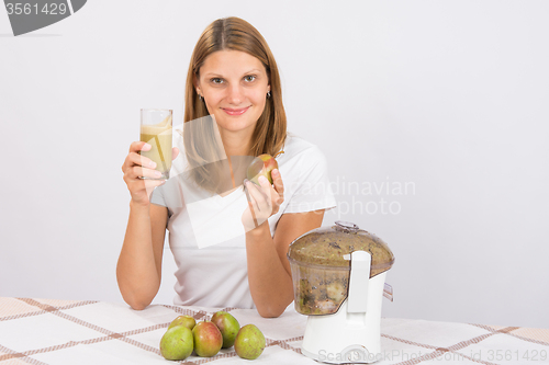 Image of Girl with a pear and a glass of fresh juice in hand