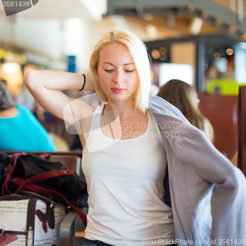 Image of Female traveler putting on her jacket.