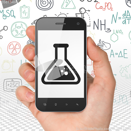 Image of Science concept: Hand Holding Smartphone with Flask on display