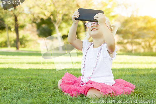 Image of Little Girl In Grass Taking Selfie With Cell Phone