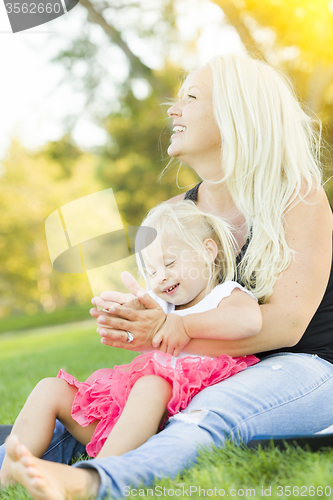 Image of Mother and Little Girl Having Fun Together in Grass